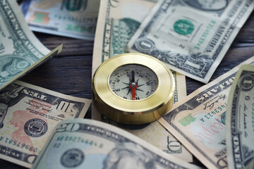 Fototapeta na wymiar Money bill with golden Compass. Bullets and cartridge cases as a military concept. Close up US Currency and compass. business, financial idea, concept, symbol of crisis, inflation