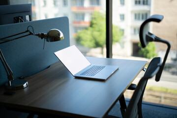 Office laptop on desk. Blank white screen.