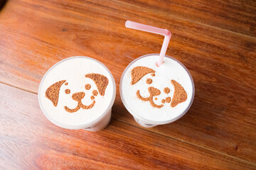 Puppy face of latte art cappuccino foam on wooden table.