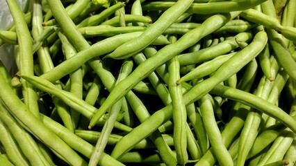 A pile of green beans sell in the market stall after harvest from field