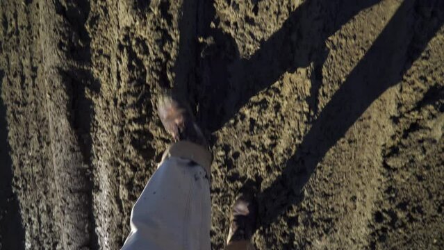 Feet in boots walking on muddy gumbo road on spring day