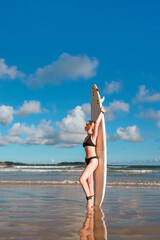 Surfing, Girl surfer with a longboard on the beach of Weligama, Indian Ocean Active water sports, travel, surf school, surf camps. Active lifestyle