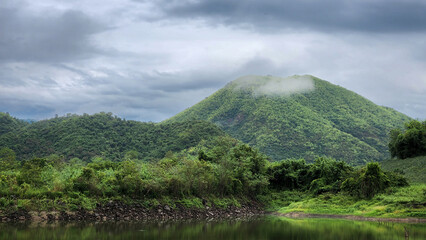 Small white cloud on green big mountains and lake river in rainy season.