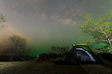 Hiking tent camping with light sky and galaxy milky way on sea mountain night sceenon sky of Thailand, Long exposure photograph, with grain noise.