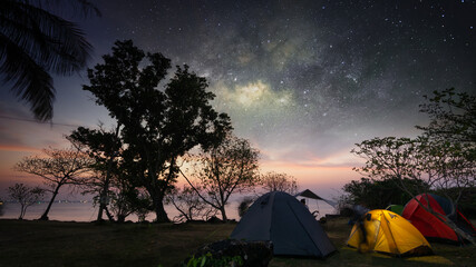 Hiking tent camping  on sea beach with light sky and galaxy milky way night scene on sky of Thailand, Long exposure photograph, with grain noise.