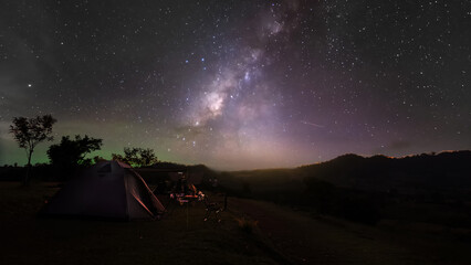 Hiking gray tent camping with light sky and galaxy milky way on high mountain night sceenon sky of Thailand, Long exposure photograph, with grain noise.