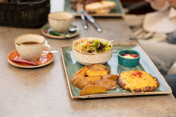 breast cutlet topped with creamy sauce and melted cheese, served with roasted potato and coleslaw