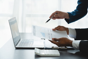 Modern businessmen are discussing, consulting and meeting about financial statistical partnerships. Discussing and finding information, calculating, analyzing charts and graphs in the office.