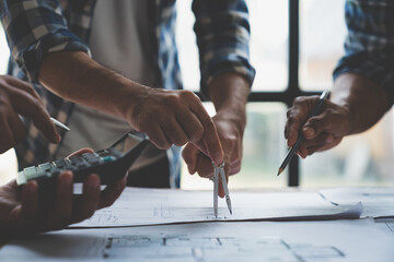 Meeting of plans and calculations on house plan drawings of engineers, architects on blue print with equipment discussing at desk. Teamwork and management concept. Construction