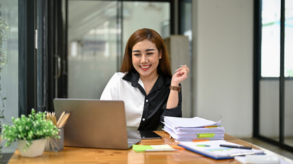 A female accountant working on her work at her desk in the office.