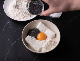photo flour, cottage cheese, hand in the frame sprinkling poppy seeds