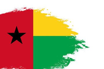 Guinea Bissau flag on a stained stroke brush painted isolated white background with copy space