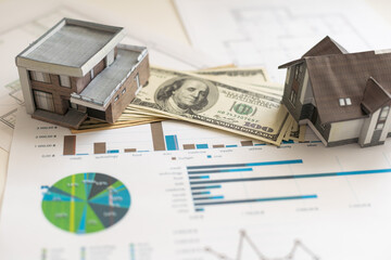 paper house model on background of US dollars banknotes. Housing market, purchase or rental of real estate