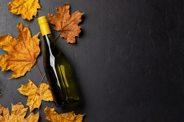 White wine bottle and autumn leaves