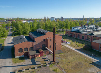 A vintage factory in Malmö, Sweden made of red bricks with a chimney.  - 605571842