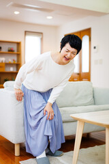 家で膝の痛みに苦しんでいる成熟した日本人女性