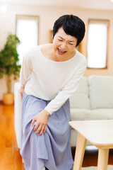 Obraz na płótnie Canvas 家で膝の痛みに苦しんでいる成熟した日本人女性
