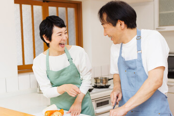 キッチンで食事の準備をしている成熟した日本のカップル