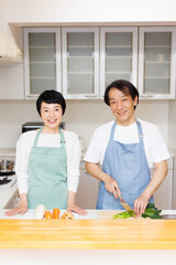 キッチンで食事の準備をしている成熟した日本のカップル