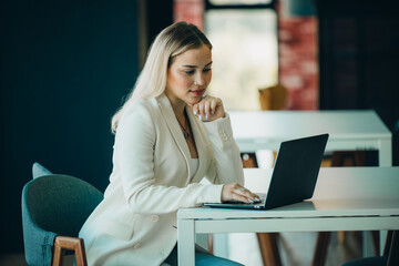 Shot of college students use laptops and tablets to complete homework and assignment. Socializing with friends in academic library. Self-discipline, practiced in positive and inspiring atmosphere
