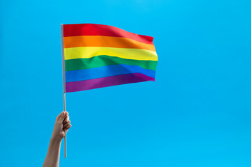 Rainbow flag waving on blue background
