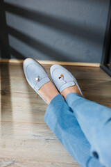 Slender female legs in jeans and blue loafers. Collection of summer women's shoes. Stylish women's...