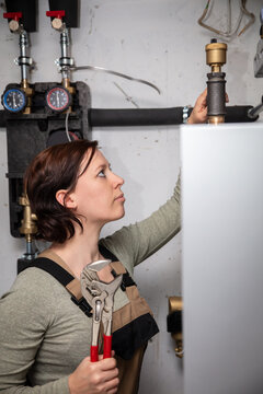 female plumber with a pellet heating system in the basement