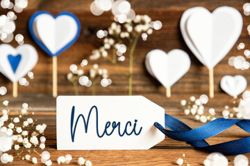 Label With White Decoration, Heart, Flower, Text Merci Means Thank You