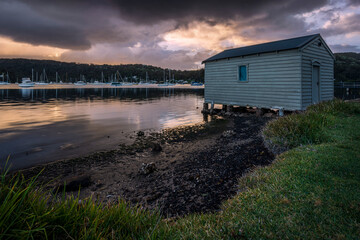 Boat house and grass at sunrise in Wagstaffe on NSW Central Coat with water