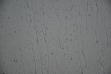 Regen fällt: Wasser rinnt an Scheibe runter bei grauen Regenwetter.
