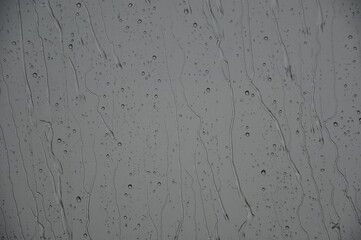 Regen fällt: Wasser rinnt an Scheibe runter bei grauen Regenwetter.