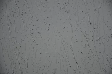 Fotobehang Regen fällt: Wasser rinnt an Scheibe runter bei grauen Regenwetter. © CSschmuck