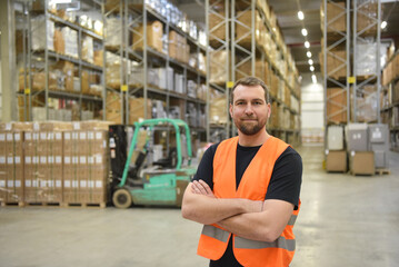 portrait of friendly warehouse worker in a forwarding agency - interior with forklift - transport and storage of goods - obrazy, fototapety, plakaty