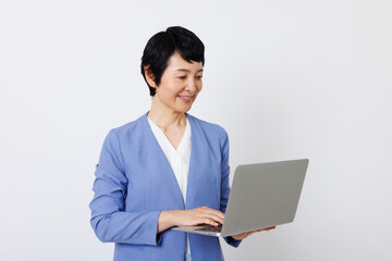 ラップトップ付きのスマートカジュアル服を着た成熟した日本人女性
