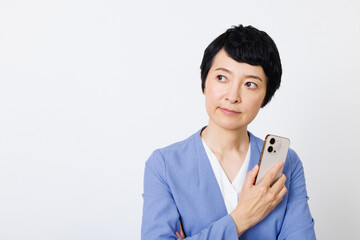 携帯電話付きのスマートカジュアル服を着た成熟した日本人女性