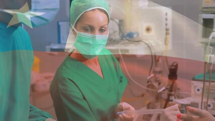 Animation of waving texas flag against team of diverse surgeons performing surgery at hospital - Powered by Adobe