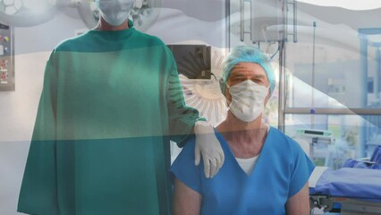 Animation of waving argentina flag against caucasian male and female surgeons at hospital - Powered by Adobe