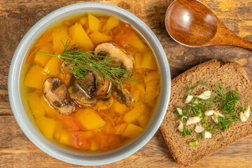 Mushroom Pumpkin Soup in ceramic bowl over wooden background.