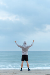 Man looking to the horizon and raising hands