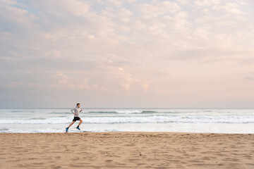 Fototapeta na wymiar Sportsman running at the beach at sunrise