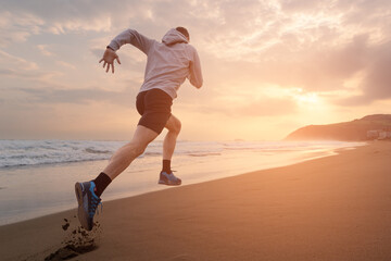 Rear view of athlete running fast at the beach