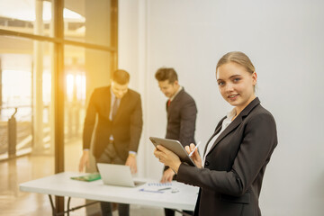 Group of Smiling Businessmen Working on Laptops at Desk in Office With Caucasian Colleagues using Digital Tablet During General Project Meeting