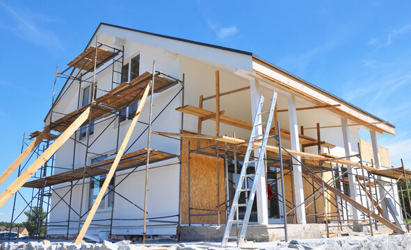 Painting House Wall Facade During Exterior Renovations. Painting Facade House Walls After Renovation And Remodel With Stucco, Plastering, Insulation.