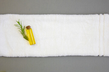 Rosemary oil on a white towel. Natural cosmetics for body and hair care.