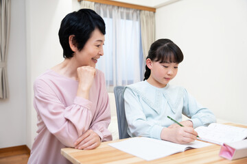 成熟した日本人女性は、勉強中に孫娘に同行します