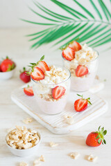 Desserts of cookies and whipped cream with strawberries in glasses, background and foreground in blur