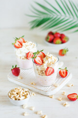 Obraz na płótnie Canvas Desserts of cookies and whipped cream with strawberries in glasses, background and foreground in blur