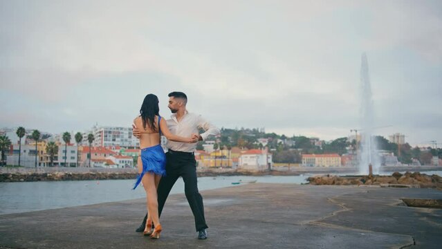 Passionate pair performing latin american dance on embanking. Couple dancing 