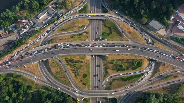 Multi lane motorway ring road with traffic jam and moderate car traffic. Aerial top view. Fast speed motion.