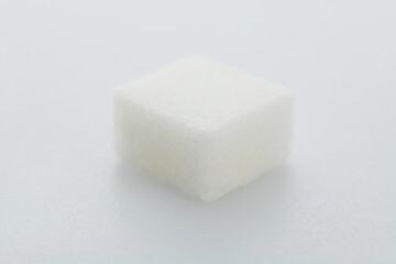 One sugar cube on white background